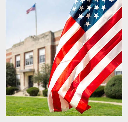 U.S. Flag with school in background