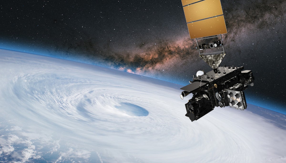 Satellite hovers in space over earth and the eye of a hurricane