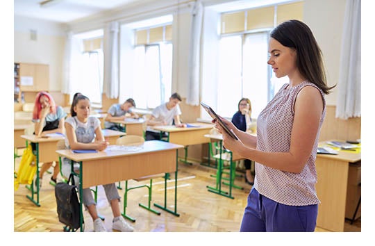 teacher in front of elementary school classroom