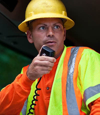 Utility worker using XL Onboard 85M P25 mobile radio