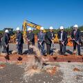 Leaders break ground with shovels and dirt on a new facility