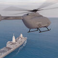Helicopter hovers with ship in the background