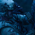 Soldier uses night vision goggles to assess a tire