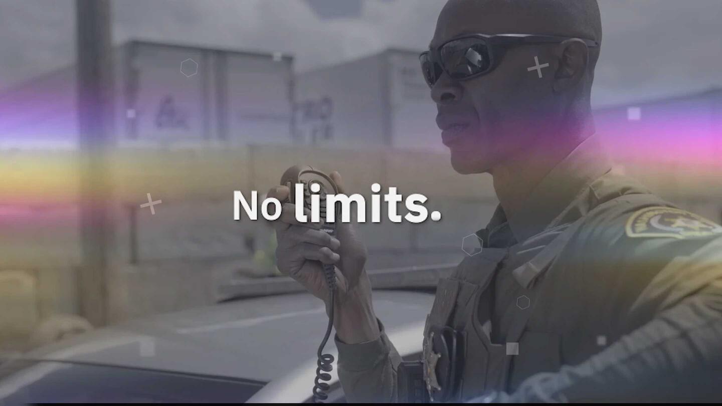 L3Harris The Power of Choice video opening frame - police officer next to his vehicle on his car radio.