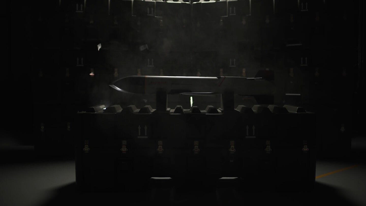 L3Harris' Launched Effects, Meet the "Wolf Pack" video still frame showing Red Wolf™ on display in darkened room resting on packing crates