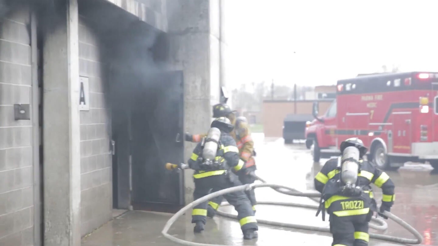 Firefighters entering burning structure