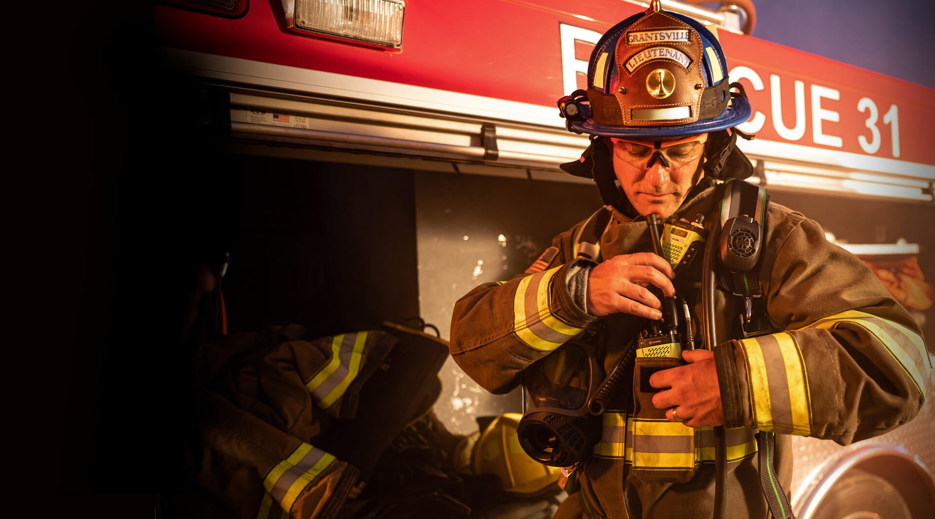 Firefighter with XL Extreme Fire Radio in front of fire truck