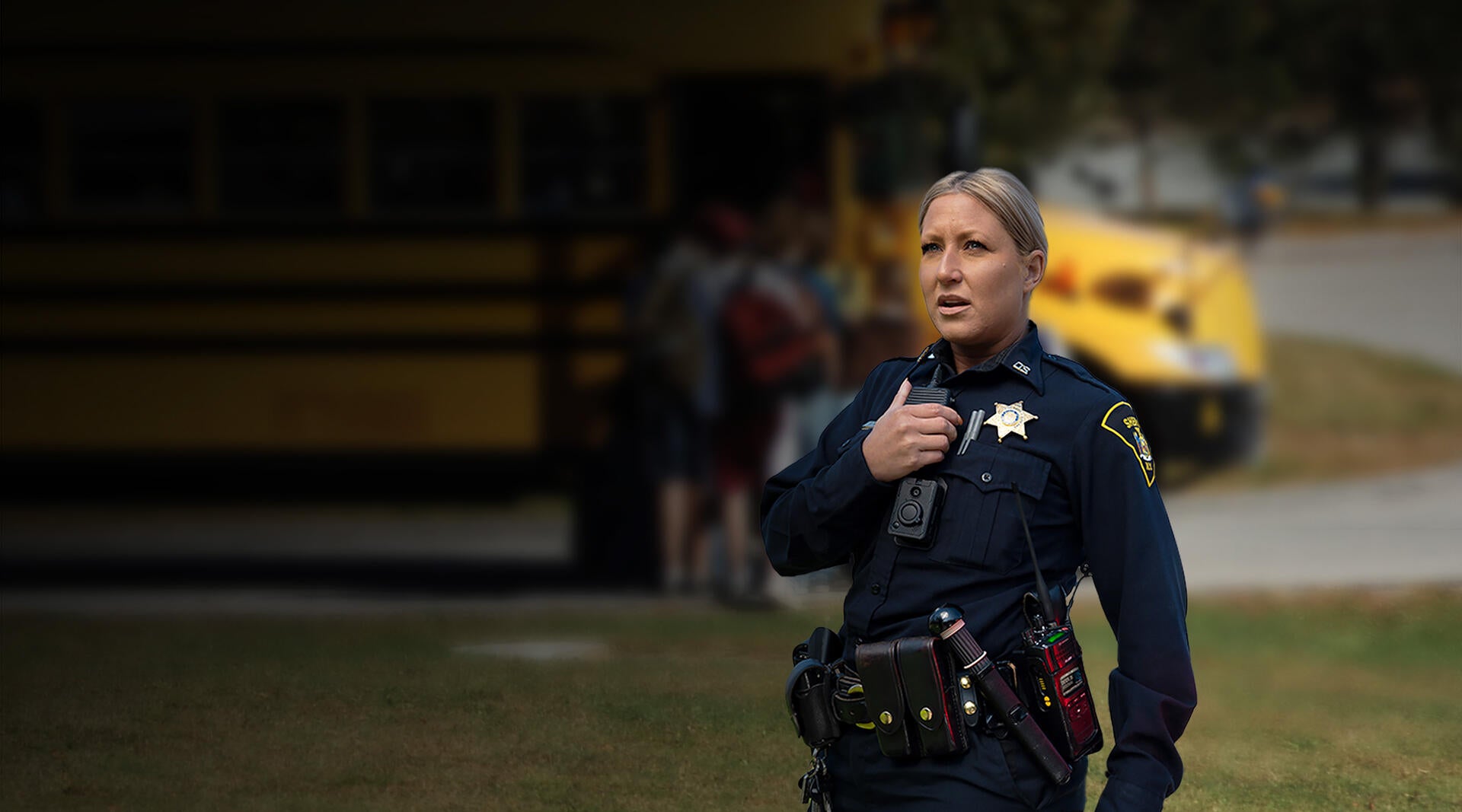 Sheriff with XL Converge radio near school bus