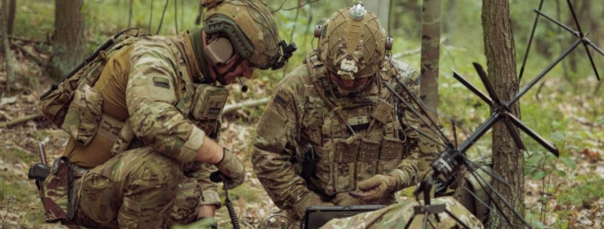 Soldiers performing tactical communications in forest