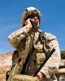 Soldier looking up at sky while on radio