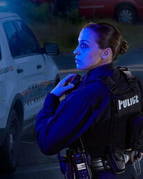 Police officer with XL 200P radio at scene of car accident