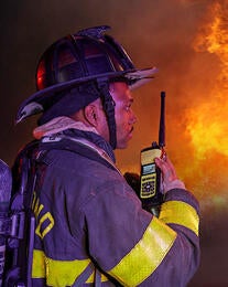 Firefighter with XL Extreme 400P in front of blazing fire
