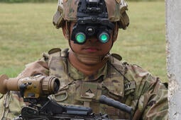 Soldier in uniform wearing night vision goggles