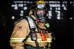 A firefighters dons the NFPA 1802 standard-certified, L3Harris XL Extreme™ 400P radio and XL Extreme Speaker Microphone.