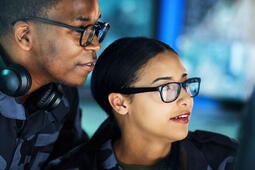 Navy soldiers looking at a computer screen