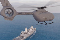 Helicopter hovers with ship in the background