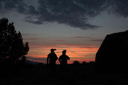 Soldiers wearing helmet-mounted night vision at dusk