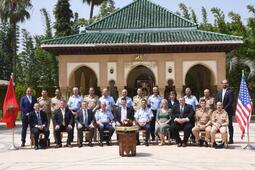 Delegates stand for a photo between two flags