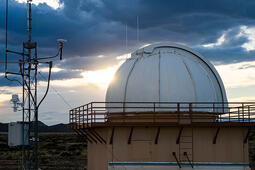 Sun reflects on a dome with technology in the foreground
