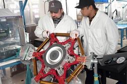 Two workers working on AEPS thrusters for NASA Glenn Research Center