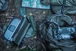 Pieces of military communications devices lie on the ground