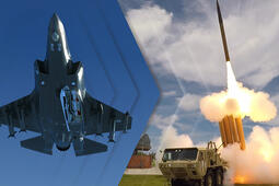 A jet flies through the air and a missile launches from a ground launcher