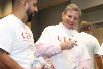 CEO Chris Kubasik helps volunteers