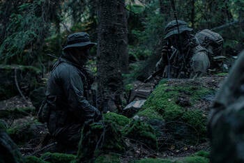 soldiers in camouflage in wooded area