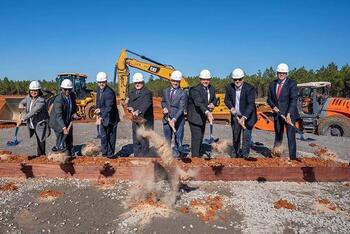 Leaders break ground with shovels and dirt on a new facility