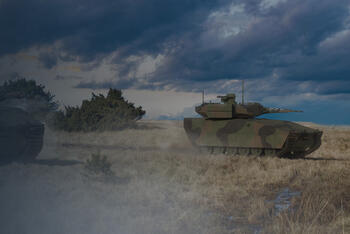 A few tanks in a field underneath a rolling sky
