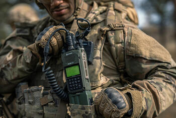 Joint Forces warfighter with AN/PRC-163 handheld radio