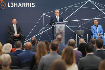 L3Harris Christopher E. Kubasik speaks at a podium at a facility
