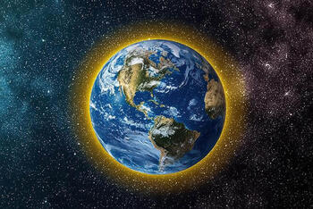 Earth from space with a yellow glow around the atmosphere