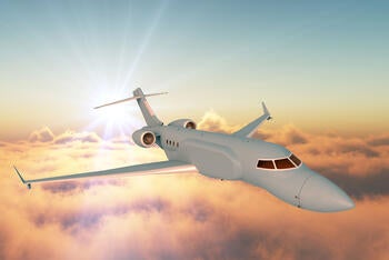 L3Harris' concept graphic of the right side, forward view of the AERIS X Bombardier Global 6500 Variant in flight with sunset sky and cloud background