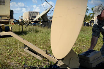 soldier setting up SATCOM radio dish antenna