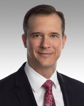 Jon Rambeau wears a suit and tie for a portrait