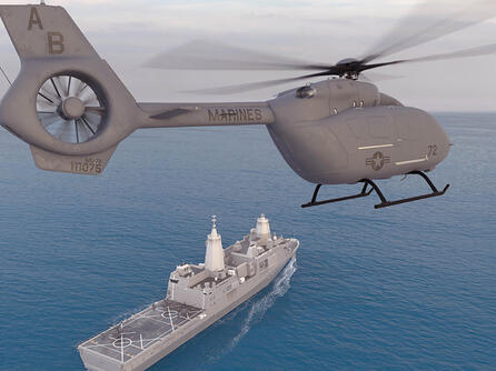 Helicopter hovers with ship in the background
