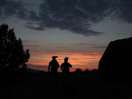 Soldiers wearing helmet-mounted night vision at dusk