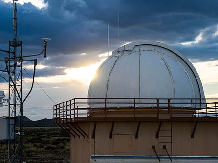 Sun reflects on a dome with technology in the foreground