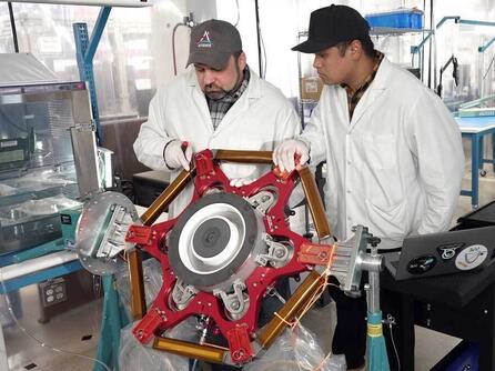 Two workers working on AEPS thrusters for NASA Glenn Research Center