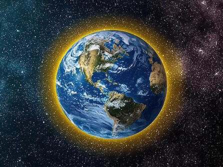 Earth from space with a yellow glow around the atmosphere
