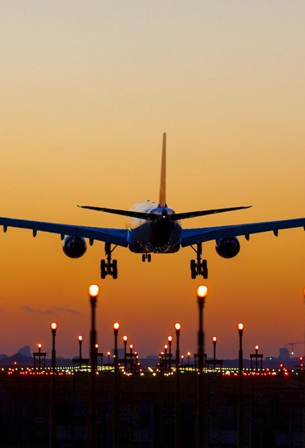 Commercial aircraft landing with sunset