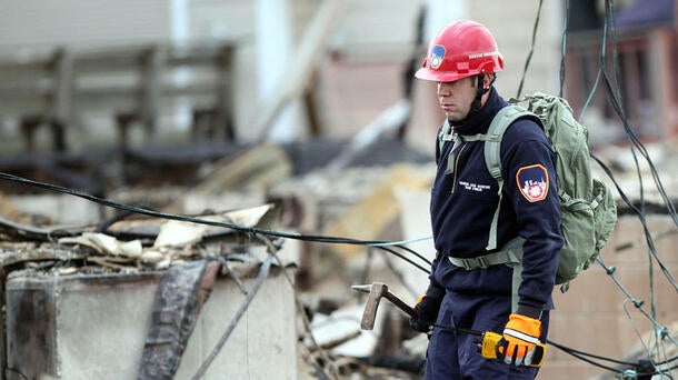 Utility worker with portable radio at natural disaster site