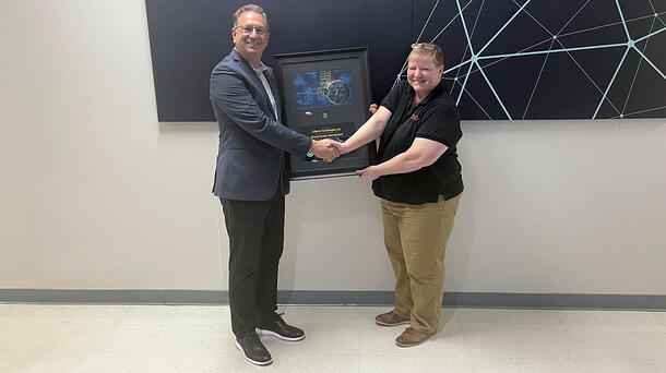 Rob Mitrevski accepting plaque from Pam Sullivan