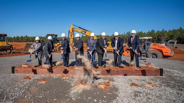 Leaders break ground with shovels and dirt on a new facility