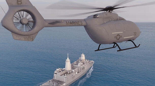 Helicopter hovers with ship in the background
