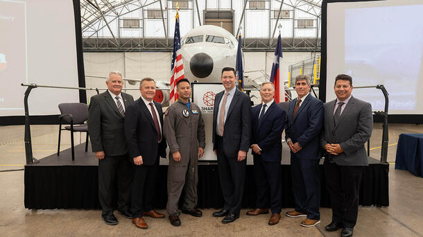 Delegates stand in front of the next delivery