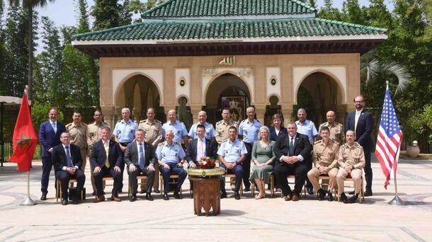 Delegates stand for a photo between two flags