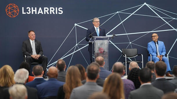 L3Harris Christopher E. Kubasik speaks at a podium at a facility