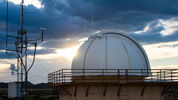 Sun reflects on a dome with technology in the foreground